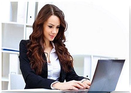 Woman sitting at the laptop to work.  Stand up to burn more calories.