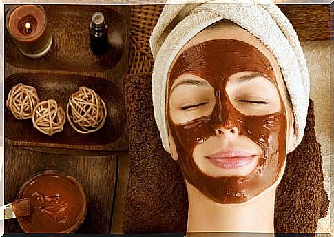 A relaxed woman with a face mask for dry skin lies there with her eyes closed.