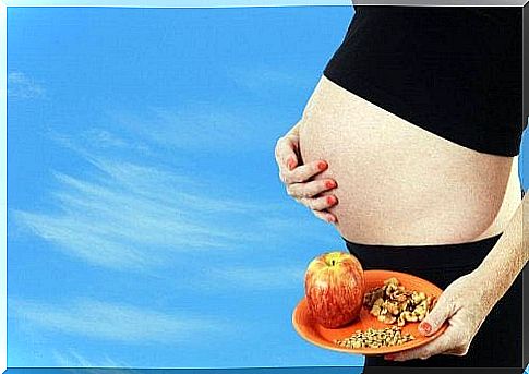 A pregnant woman is holding a plate of groceries.