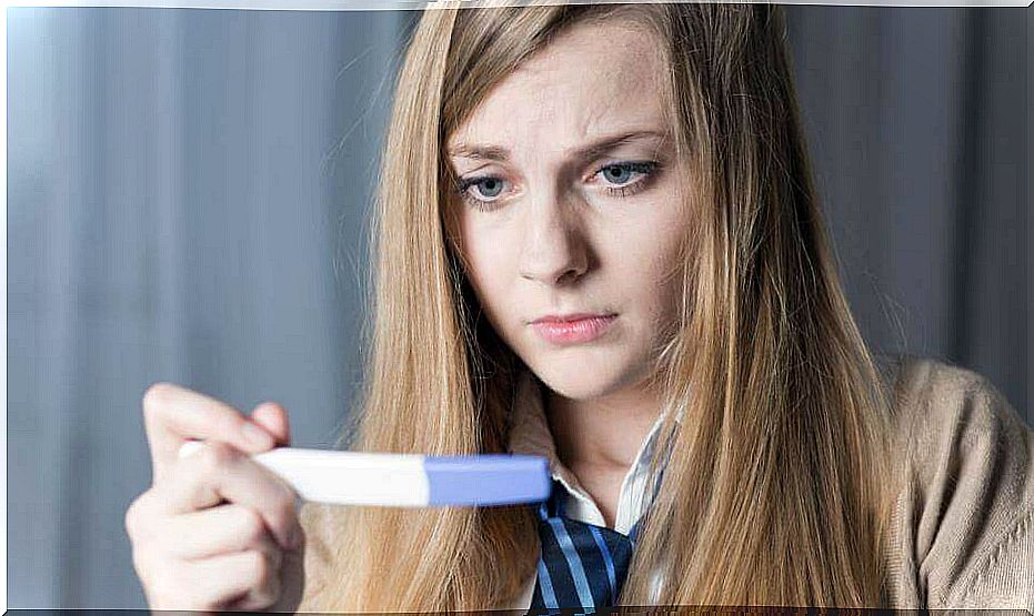 Woman looks at a pregnancy test